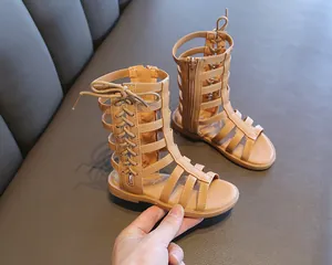 Close-up of brown girls gladiator sandals with cross straps and back zipper detail