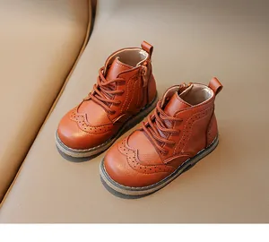 Close-up of brown leather children's boots featuring brogue details and side zipper