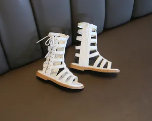 Detail of white gladiator sandals for girls featuring a high-top design with side zipper