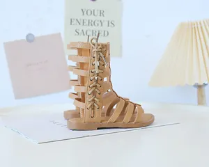 Detailed macro view of camel brown leather gladiator sandals with cross strap design