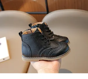 Close-up of black children's brogue boots with side zipper and carved floral details