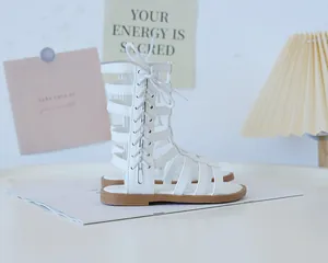 Detail of white high-top gladiator sandals for girls with lace-up straps and flat soles