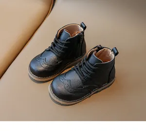 Close-up of black leather children's boots with brogue detailing and side zippers