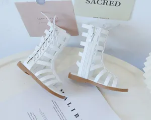 Close-up of white gladiator sandals with cross straps and side zipper closure