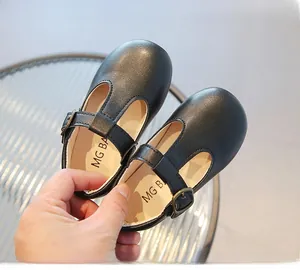 Détail de chaussures Mary Jane noires à bride en T pour tout-petits avec boucle en bronze