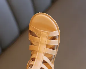 Detailed close-up of beige Roman sandals featuring multi-strap design and T-shaped stitching