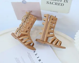 Detailed side view of girl's tan gladiator sandals with lace-up and zipper closure