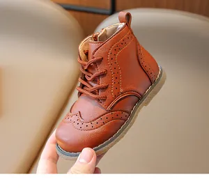 Detail of children's leather boots showing classic brogue patterns and side zipper