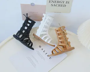 Detailed view of high-top gladiator sandals for girls in black, white, and brown colors