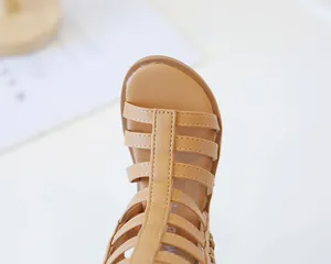 Detailed close-up of open-toe straps and stitching on khaki girls' gladiator sandals