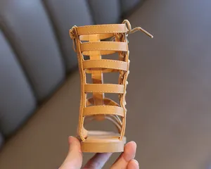 Detail view of khaki gladiator sandals featuring a zipper closure and lace-up back detail