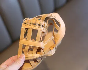 Close-up of girls' khaki Roman sandals showing hollow caged design and back zipper