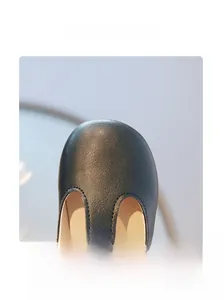 Détail macro d'une chaussure en cuir noir pour enfant avec bout rond et coutures fines