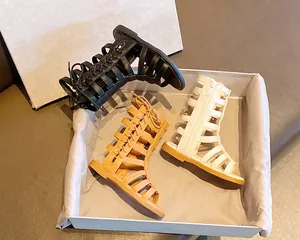 Detail view of high-top gladiator sandals for girls in black, cream, and yellow leather