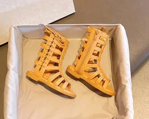 Close-up of yellow gladiator sandals with cross lacing and side zipper detail