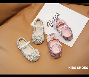Detalle de zapatos Mary Jane de purpurina con lazos grandes y correas de perlas para niñas