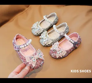 Detalle de zapatos de princesa con purpurina, lazos de pedrería y correas de perlas