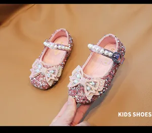 Detalle de zapatos Mary Jane rosas con pedrería para niñas con lazo y perlas