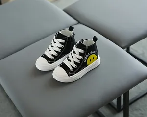 Dettaglio di scarpe alte in tela per bambini con smiley giallo e cerniera laterale