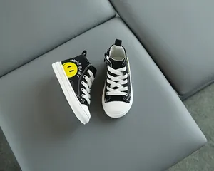 Dettaglio di scarpa alta in tela per bambini con faccina gialla e zip laterale esterna