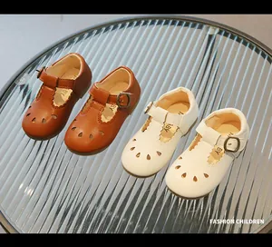 Detalle de zapatos vintage tipo T-strap para niños con recortes y bordes ondeados