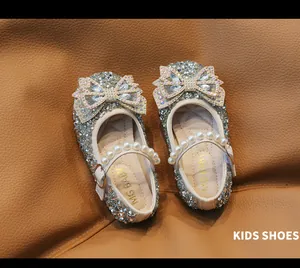 Detalle de zapatos de princesa plateados para niñas con lentejuelas y tira de perlas