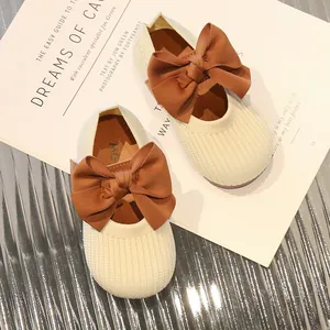 Beigefarbene Mädchen-Strickschuhe mit großer brauner Schleife und weicher Gummisohle
