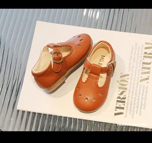 Primer plano detallado de zapatos Mary Jane de cuero marrón con patrones calados retro