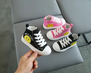 Dettaglio delle sneakers alte in tela con cerniera laterale e motivo a faccina gialla