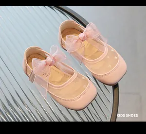 Dettaglio di scarpe Mary Jane rosa con rete a cuori e grande fiocco in organza decorativo