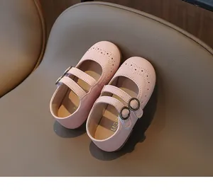 Λεπτομέρεια από ροζ παπούτσια Mary Jane με σχέδια brogue και διπλά λουράκια κουμπώματος