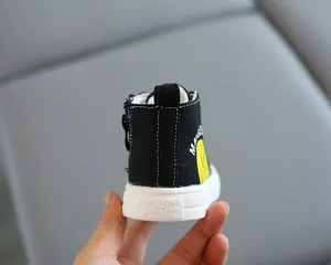 Dettaglio del tallone di scarpe in tela alte con zip laterale e logo smiley giallo