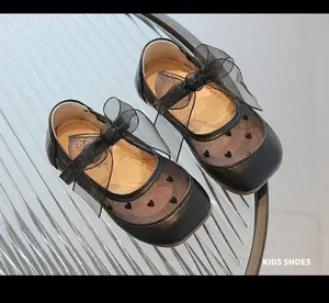 Dettaglio scarpe Mary Jane nere con ricamo a cuore e grandi fiocchi in organza