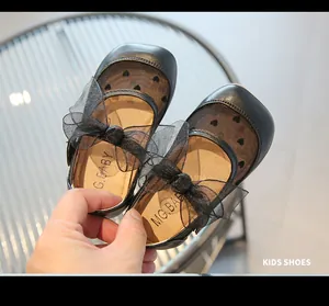 Dettaglio scarpa Mary Jane nera per bambini con rete a cuori e fiocco in organza