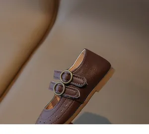 Λεπτομέρεια από σκούρα καφέ δερμάτινα παπούτσια Mary Jane με ρετρό διπλές αγκράφες