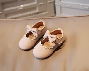 Detail view of pink Mary Jane baby shoes with lovely bow and scalloped wave edge
