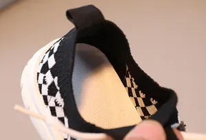 Close-up of children's platform sneakers with black and white checkerboard pattern and mesh