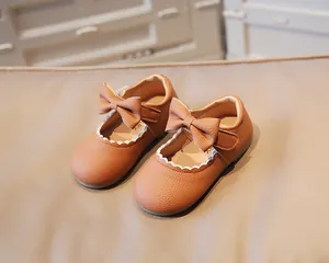 Detail of baby girl brown leather shoes featuring lychee texture and wave edges
