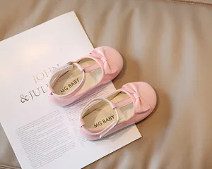 Dettaglio delle scarpe Mary Jane in pelle verniciata rosa per bambina con fiocco e cinturino