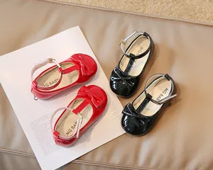 Dettaglio delle scarpe Mary Jane in vernice per bambina con cinturino a T e fiocco