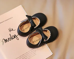 Close-up of black toddler Mary Jane shoes with bow decoration and scalloped edges