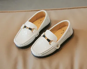 Détail de mocassins blancs pour enfants avec texture tissée et boucle en émail noir