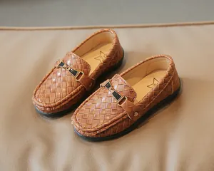 Gros plan sur des mocassins tressés marron pour enfants avec boucle en métal élégante