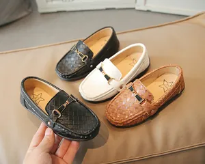 Détail de mocassins pour enfants avec texture tissée et boucle en métal doré élégante