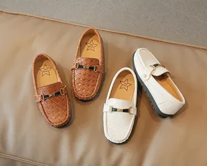 Détail de mocassins pour enfants marron et blanc avec texture tissée et boucles en métal
