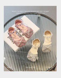 Détail de chaussures pailletées pour filles avec nœud et bride en perles roses