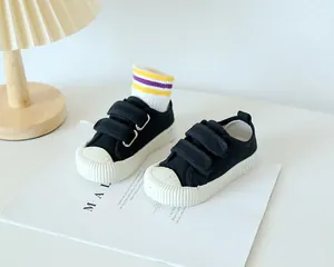Vue détaillée des chaussures en toile noire pour enfants avec double scratch et semelle gomme