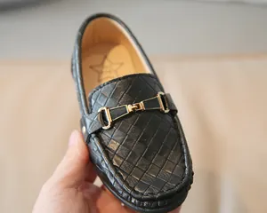 Gros plan détaillé sur des mocassins tressés noirs pour enfants avec boucle en métal doré
