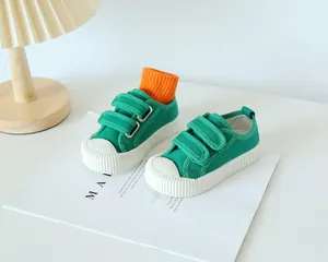 Détail de chaussure en toile verte pour enfant avec double velcro et bout en caoutchouc