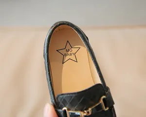 Détail de mocassins en cuir matelassé noir pour enfants avec mors doré et logo étoile